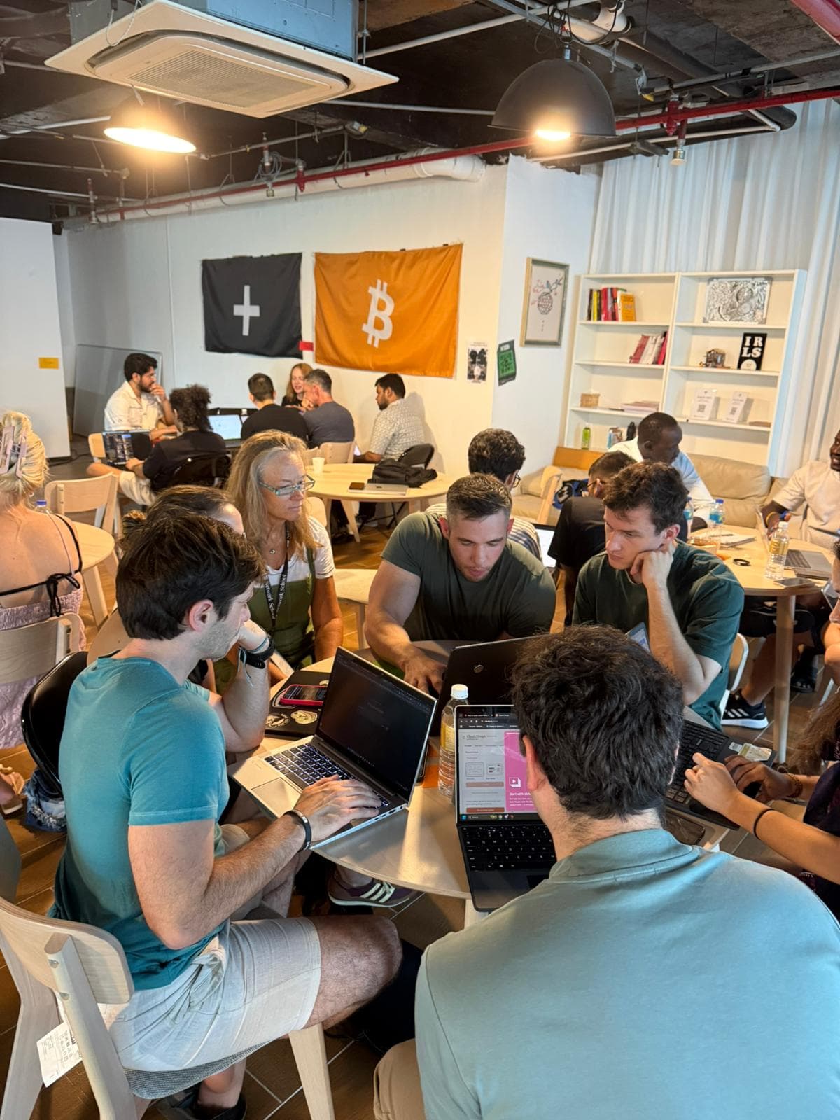 Adult cohort working on laptops at tables during a Pathwise hands-on AI workshop