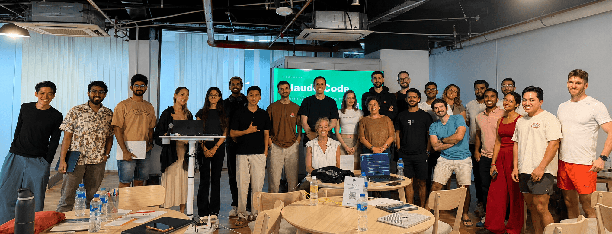 Pathwise Academy corporate cohort posed in front of the Claude Code workshop slide after a full-day hands-on AI session